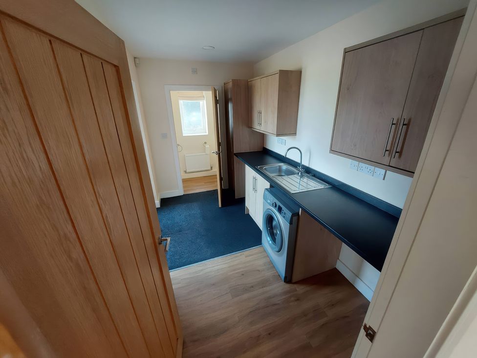 A kitchen with a washing machine and sink at Wold View in Market Rasen
