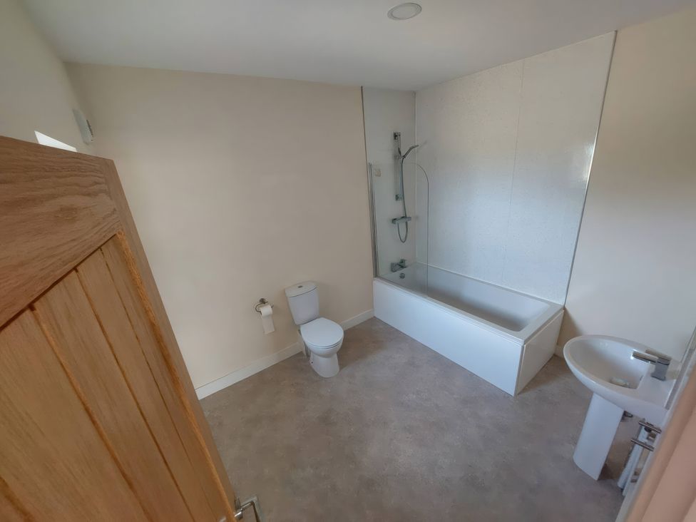 A bathroom with a bathtub, shower, toilet, and sink at Wold View in Market Rasen
