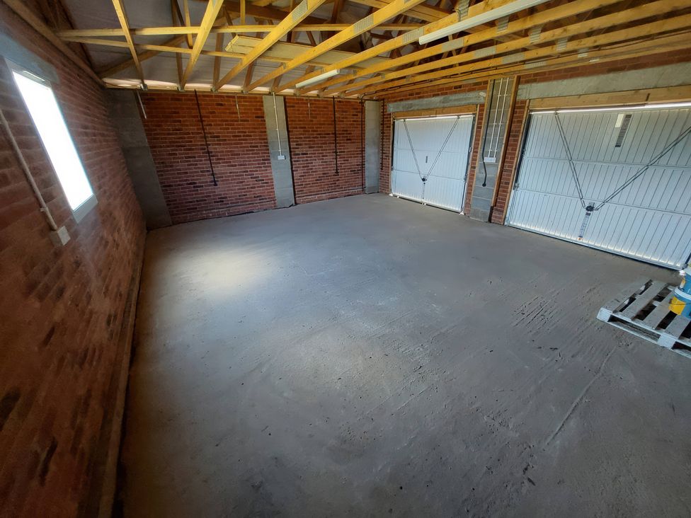A garage with concrete floor and garage doors at Wold View in Market Rasen