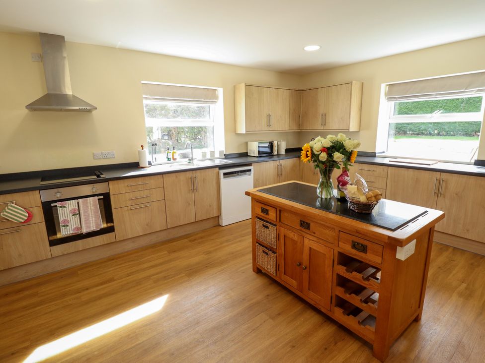 A kitchen with a stove, sink, and kitchen island at Wold View near Caistor