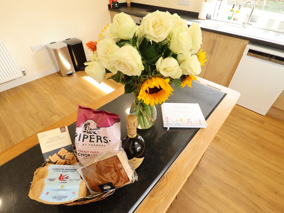 A kitchen with flowers, bread, and food items at Wold View near Caistor