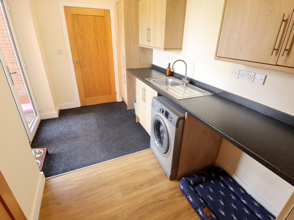 A utility room with a washing machine and sink at Wold View near Caistor