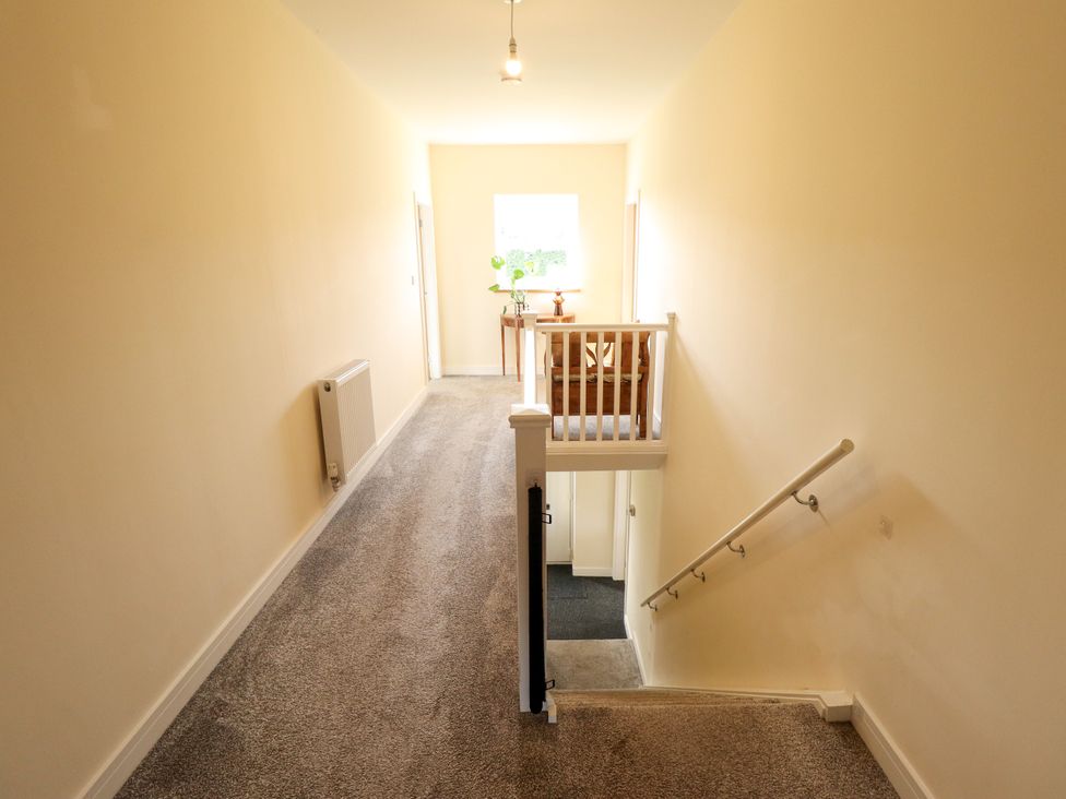 A hallway with a staircase and a plant at Wold View near Caistor