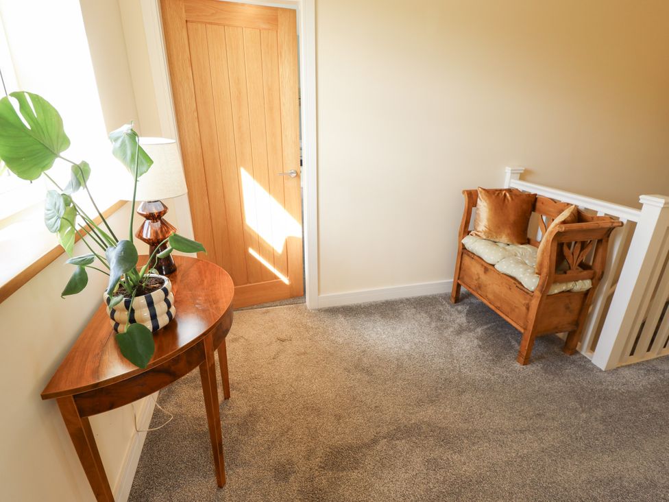 A hallway with a table, lamp and chair at Wold View near Caistor