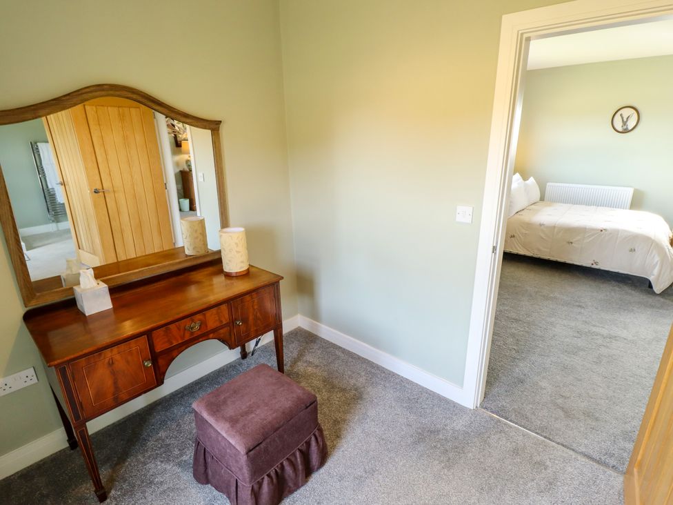 A bedroom with a vanity and stool at Wold View near Caistor