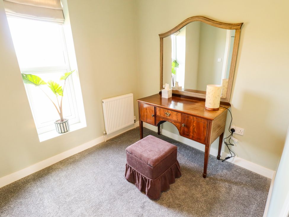 A bedroom with a vanity table and a plant at Wold View near Caistor