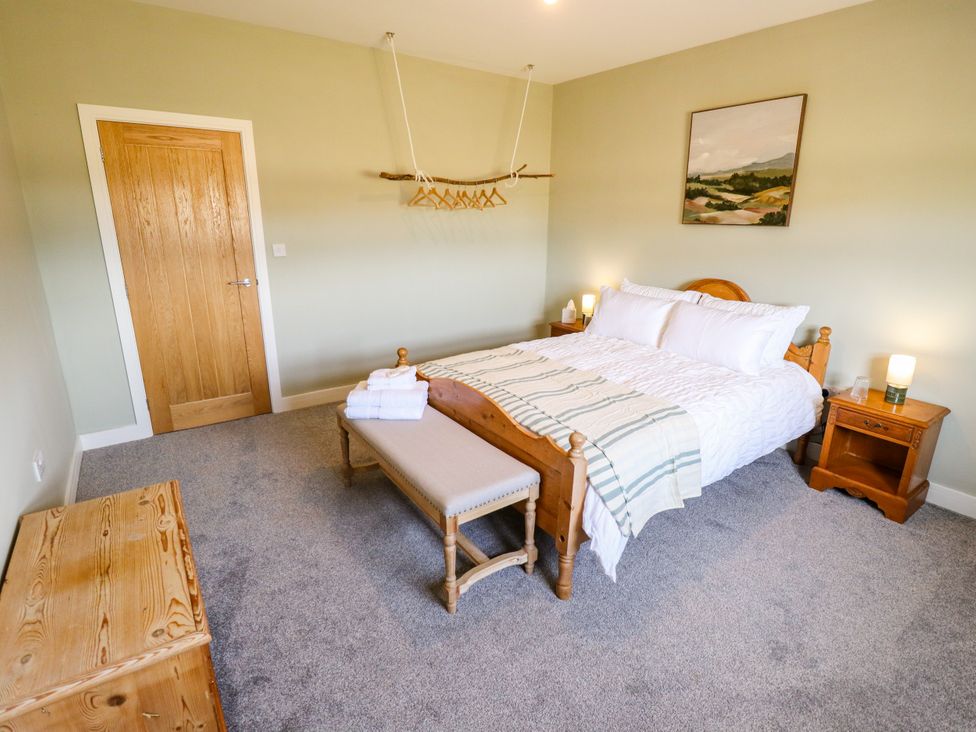 A bedroom with a bed, bedside tables, and a painting at Wold View near Caistor