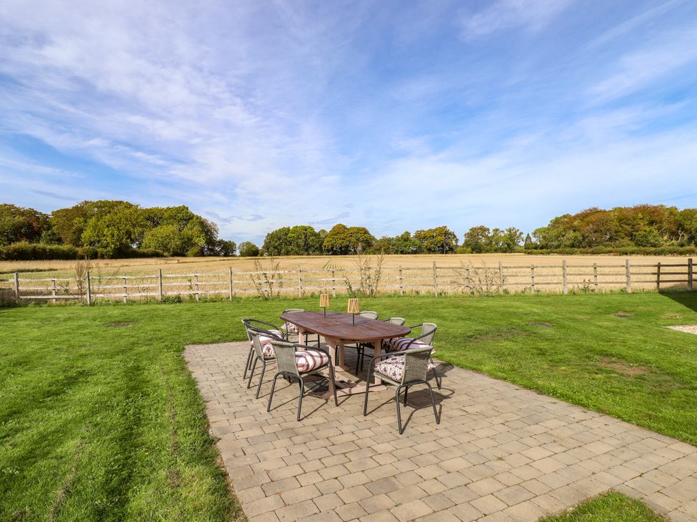 A patio with a table and chairs overlooking a field at Wold View near Caistor
