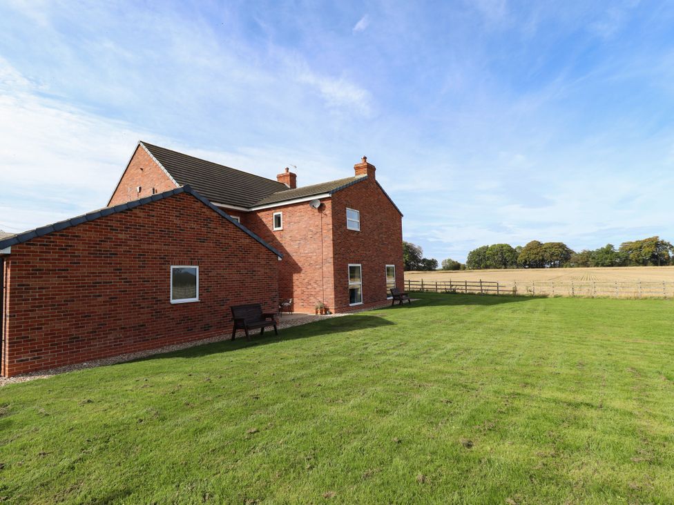A house with a lawn and benches at Wold View near Caistor