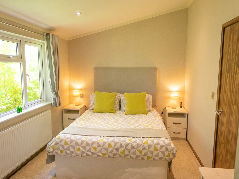 A bedroom with a bed and bedside tables at Ash Lodge Stowmarket