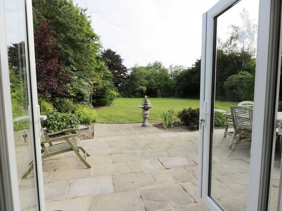 A garden with a stone patio and outdoor furniture at Millstone Cottage Beverley