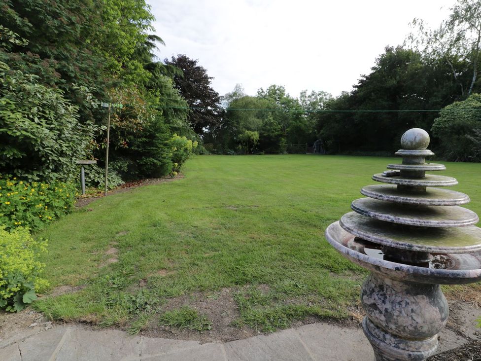 A garden with a fountain and grass at Millstone Cottage in Beverley