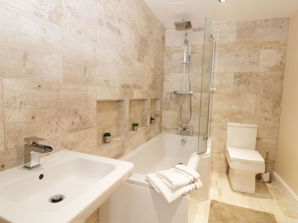 A bathroom with a bathtub and shower at Millstone Cottage Beverley