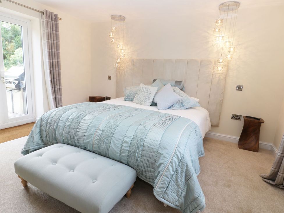 A bedroom with a bed and a patio door at Millstone Cottage in Beverley