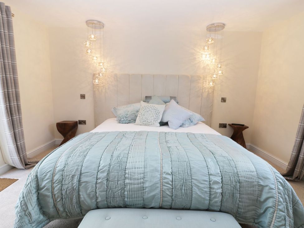 A bedroom with a bed and cushions at Millstone Cottage in Beverley