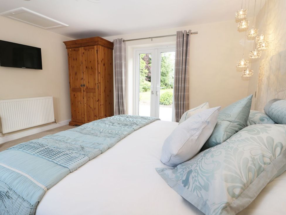 A bedroom with a bed and wardrobe at Millstone Cottage Beverley