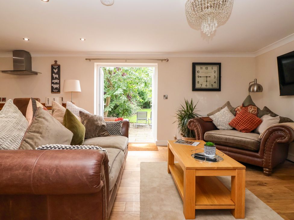 A living room with a sofa and coffee table at Millstone Cottage Leven Near Beverley