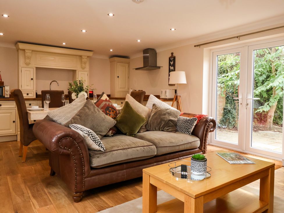 A living room with a sofa and coffee table at Millstone Cottage in Leven Near Beverley