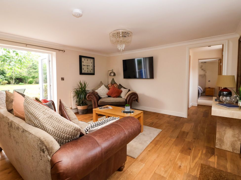 A living room with a sofa, coffee table, and television at Millstone Cottage Leven Near Beverley