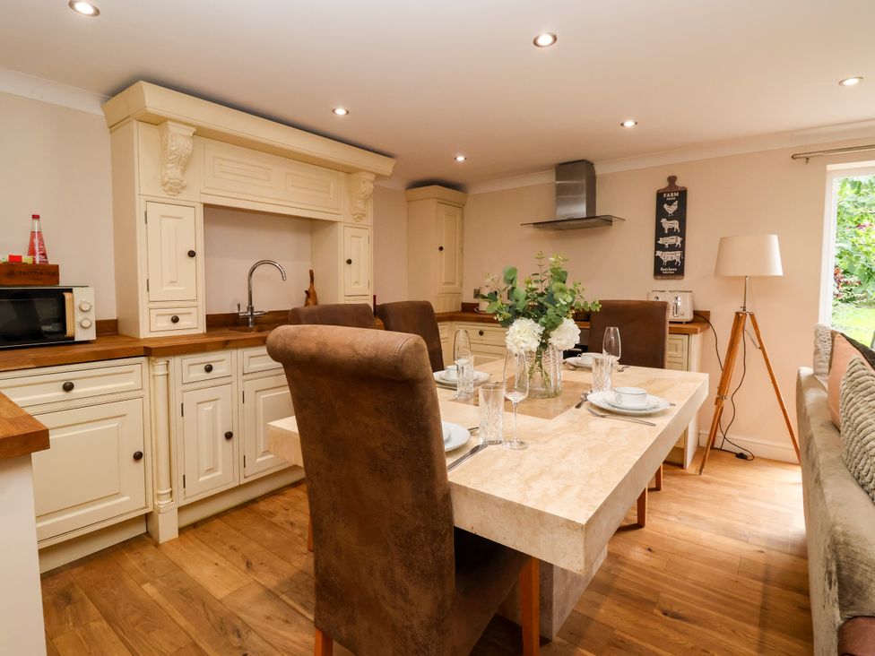 A kitchen with a dining area featuring a table and chairs at Millstone Cottage Leven Near Beverley
