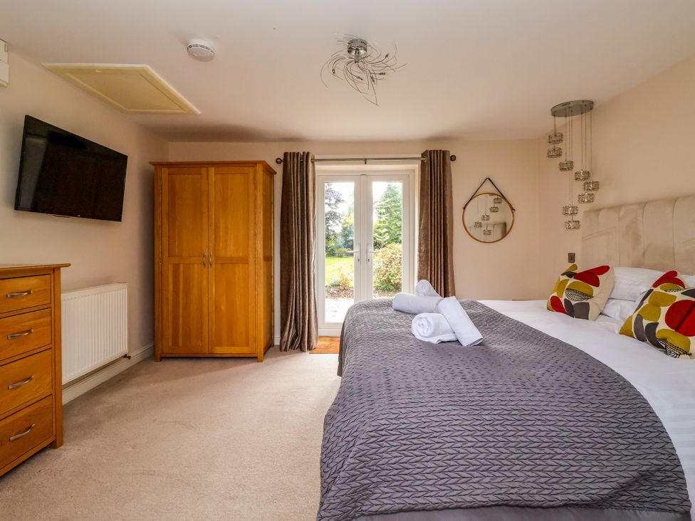 A bedroom with a bed and wardrobe at Millstone Cottage Leven Near Beverley