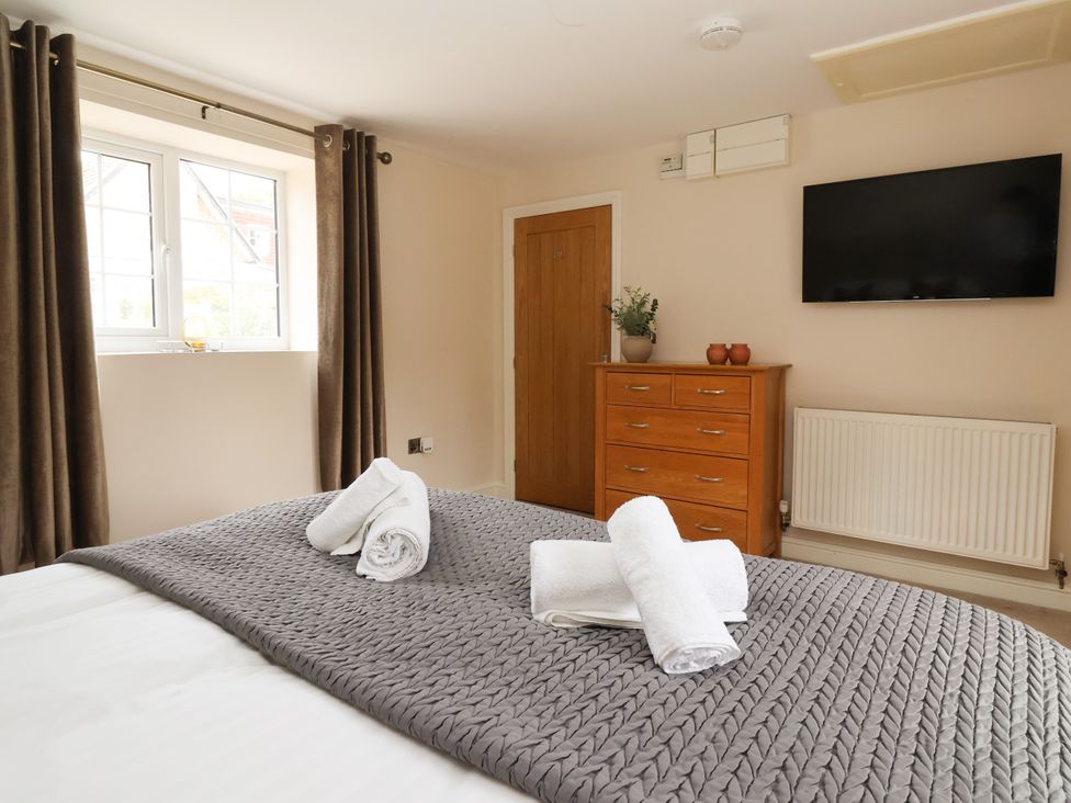 A bedroom with a bed and dresser at Millstone Cottage Leven Near Beverley