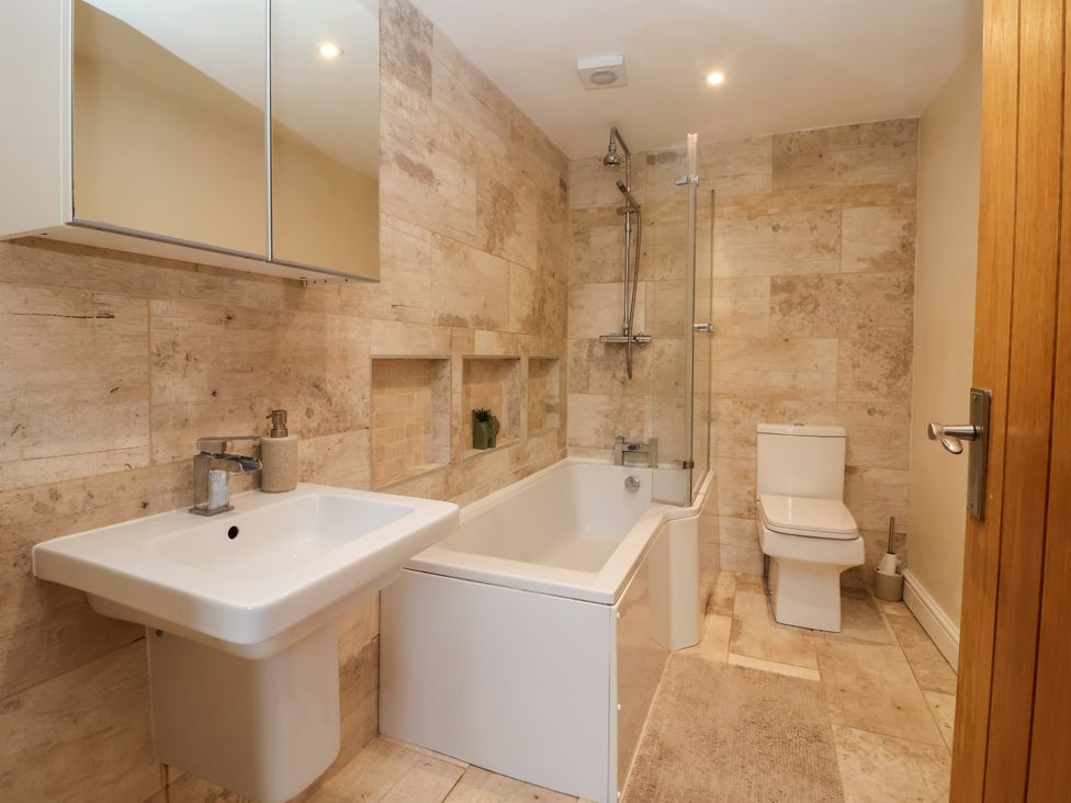 A bathroom with a bathtub and sink at Millstone Cottage Leven Near Beverley