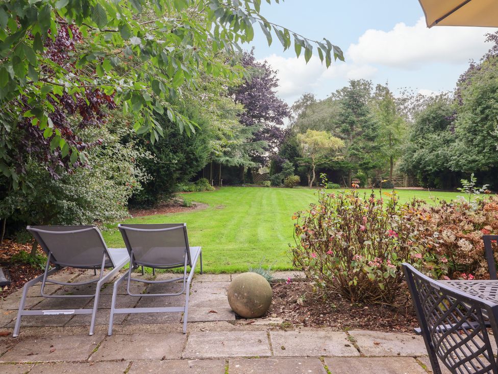 A garden with deck chairs and a lawn at Millstone Cottage in Leven Near Beverley