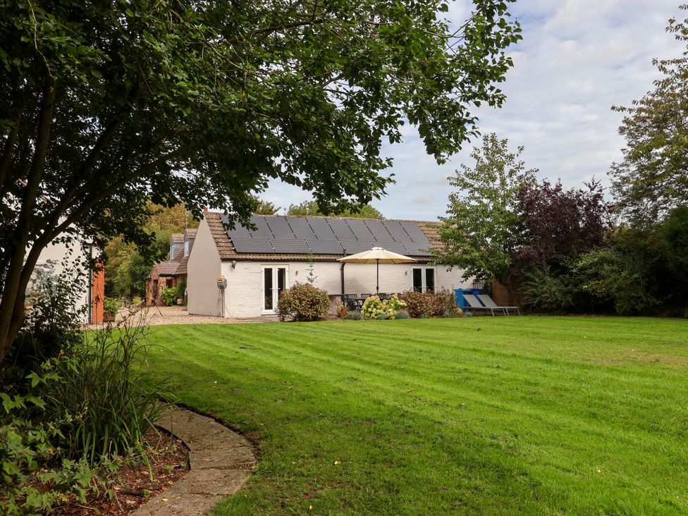 A house with solar panels and a lawn at Millstone Cottage Leven Near Beverley