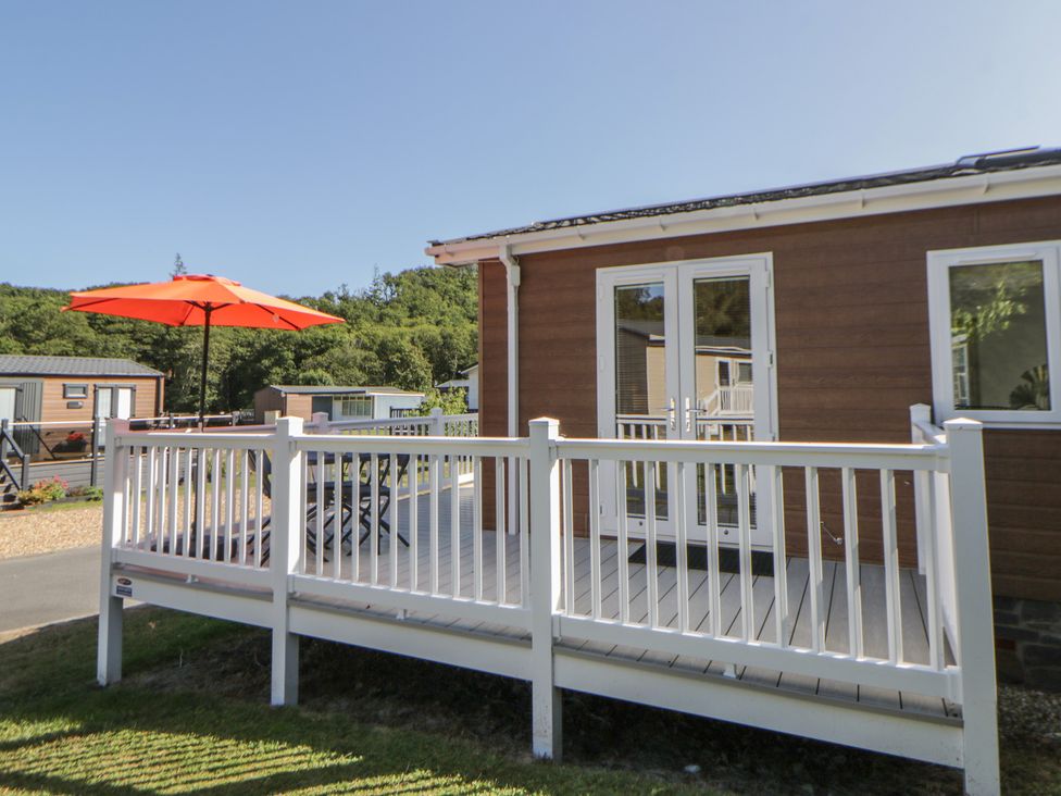 An outdoor area with a deck and umbrella at 73 Cildraeth New Quay