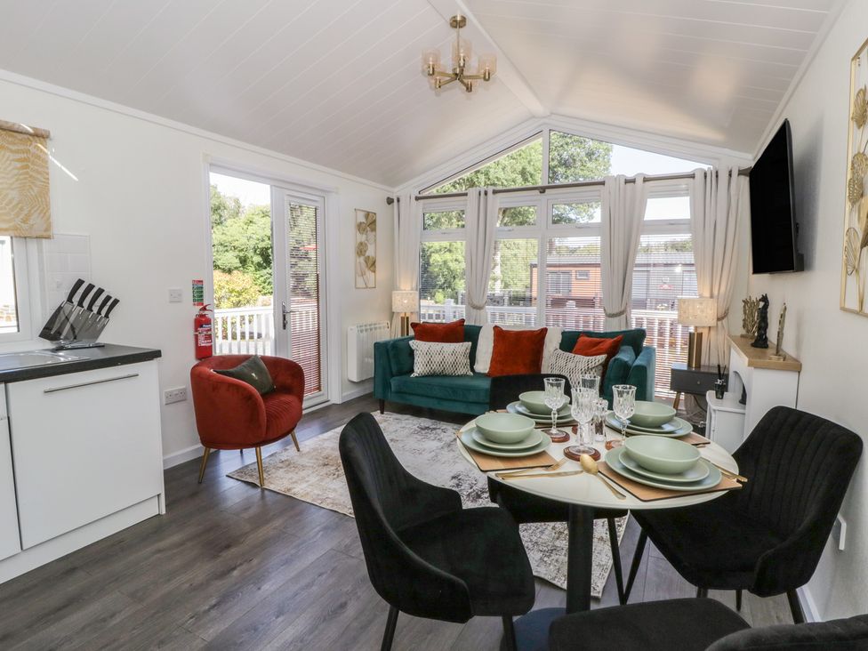 A living room with a sofa and dining area at 73 Cildraeth in New Quay