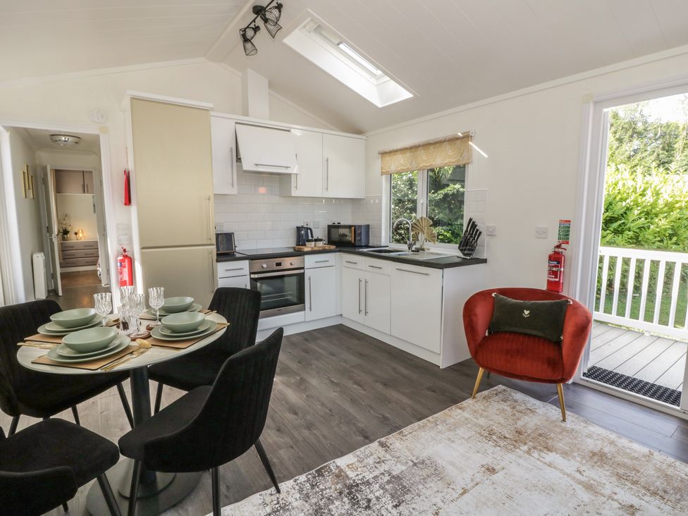 A kitchen with dining table and appliances at 73 Cildraeth in New Quay