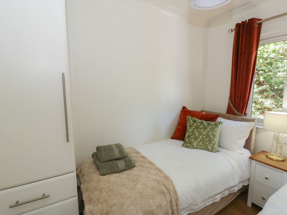 A bedroom with a bed and a side table at 73 Cildraeth in New Quay