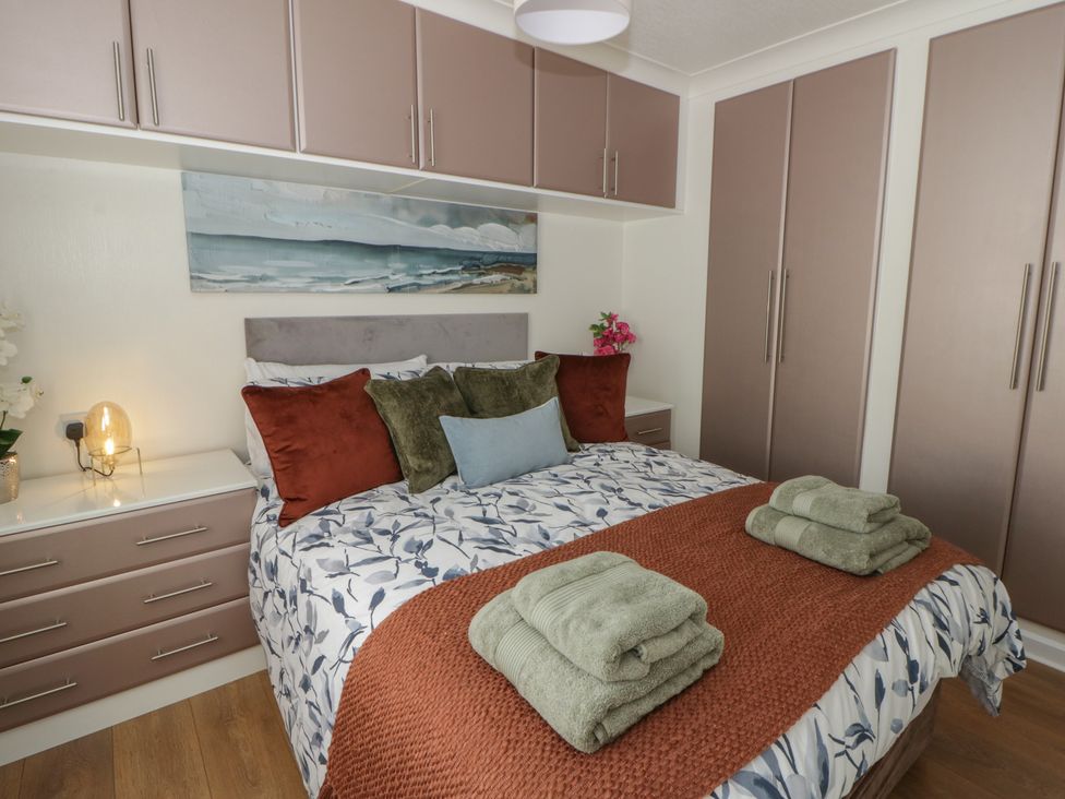 A bedroom with a bed and wardrobe at 73 Cildraeth New Quay