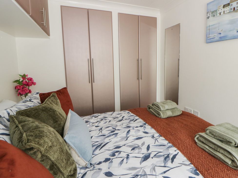 A bedroom with a bed and wardrobe at 73 Cildraeth New Quay