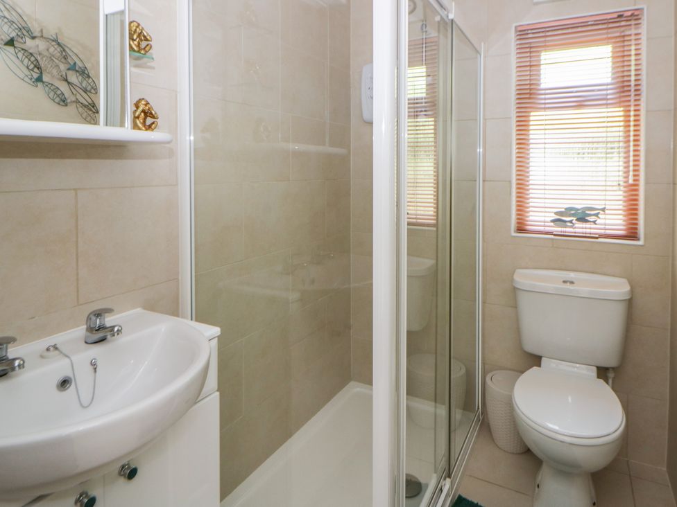 A bathroom with a shower, sink, and toilet at 73 Cildraeth in New Quay