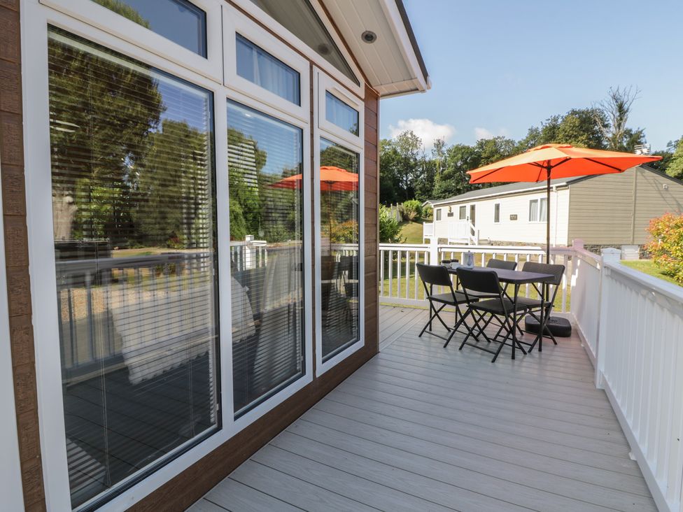 A deck with an outdoor table and chairs at 73 Cildraeth in New Quay