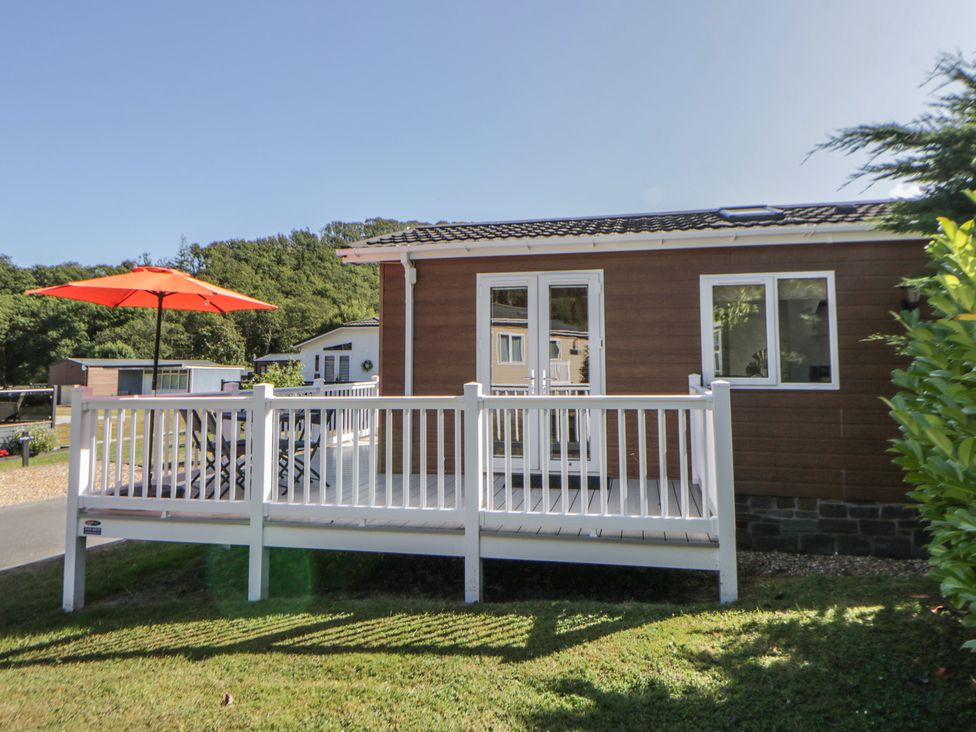 An outdoor deck with table and umbrella at 73 Cildraeth in New Quay