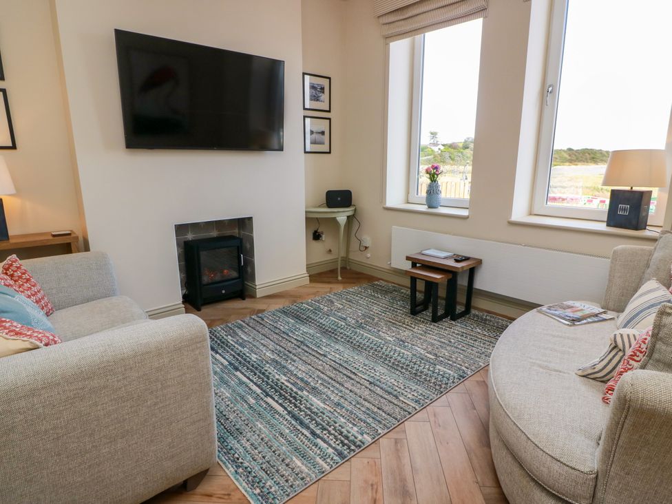 A living room with a television and electric fireplace at Sandy Toes, Powfoot, Annan