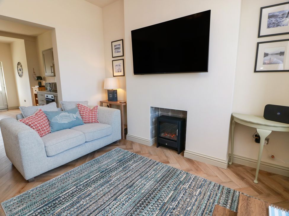 A living room with a sofa and television at Sandy Toes, Powfoot, Annan
