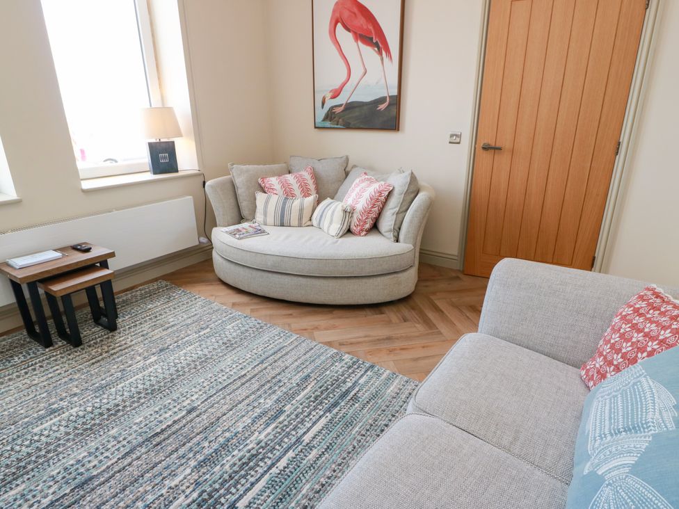 A living room with a couch and a side table at Sandy Toes in Powfoot, Annan
