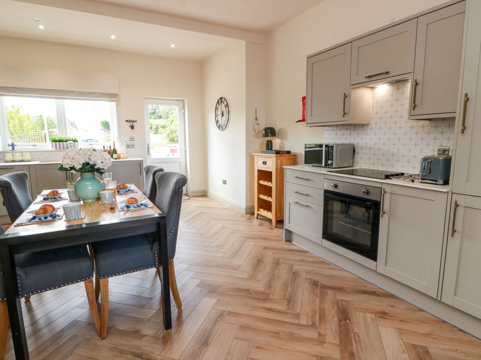 A kitchen with a dining table set for breakfast at Sandy Toes in Powfoot, Annan
