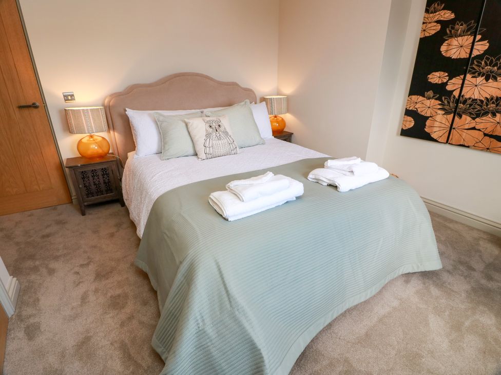 A bedroom with a bed and bedside table at Sandy Toes Powfoot, Annan