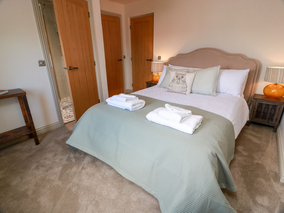 A bedroom with a bed and towels at Sandy Toes, Powfoot, Annan