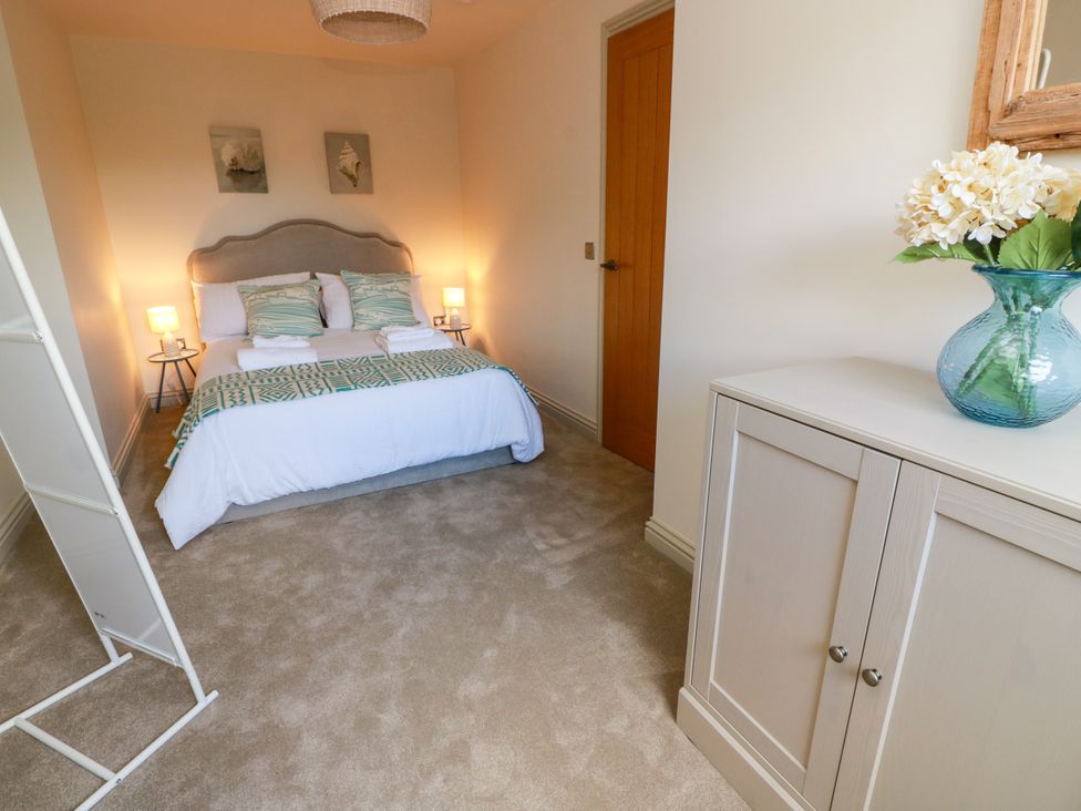 A bedroom with a bed and side tables at Sandy Toes in Powfoot, Annan