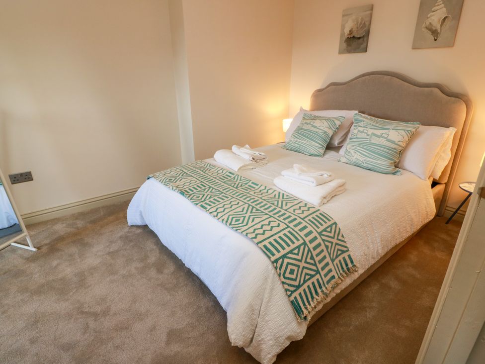A bedroom with a bed and decorative pillows at Sandy Toes in Powfoot, Annan