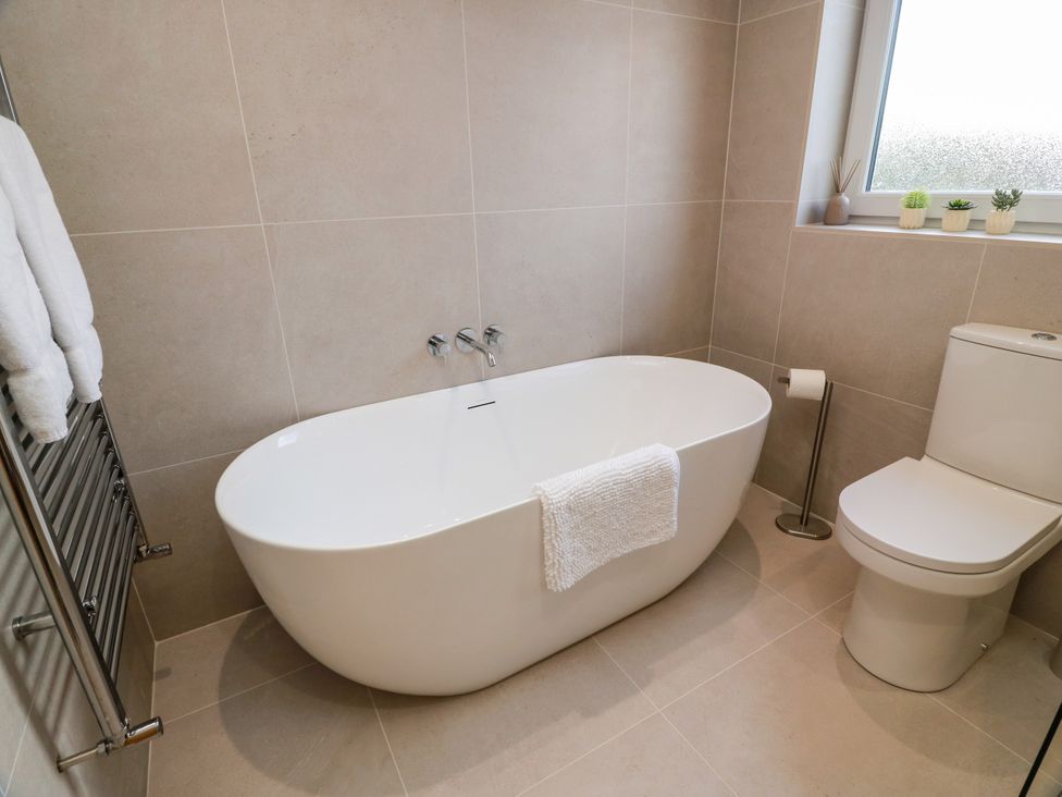 A bathroom featuring a bathtub and toilet at Sandy Toes in Powfoot, Annan