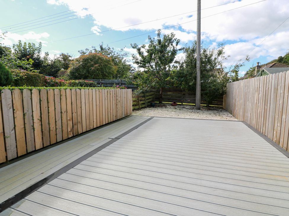 An outdoor area with decking and a wooden fence at Sandy Toes Powfoot, Annan