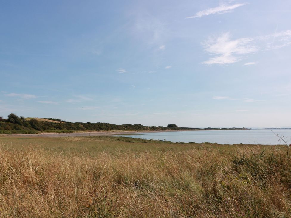 A beach view with grass and water at Sandy Toes in Powfoot, Annan