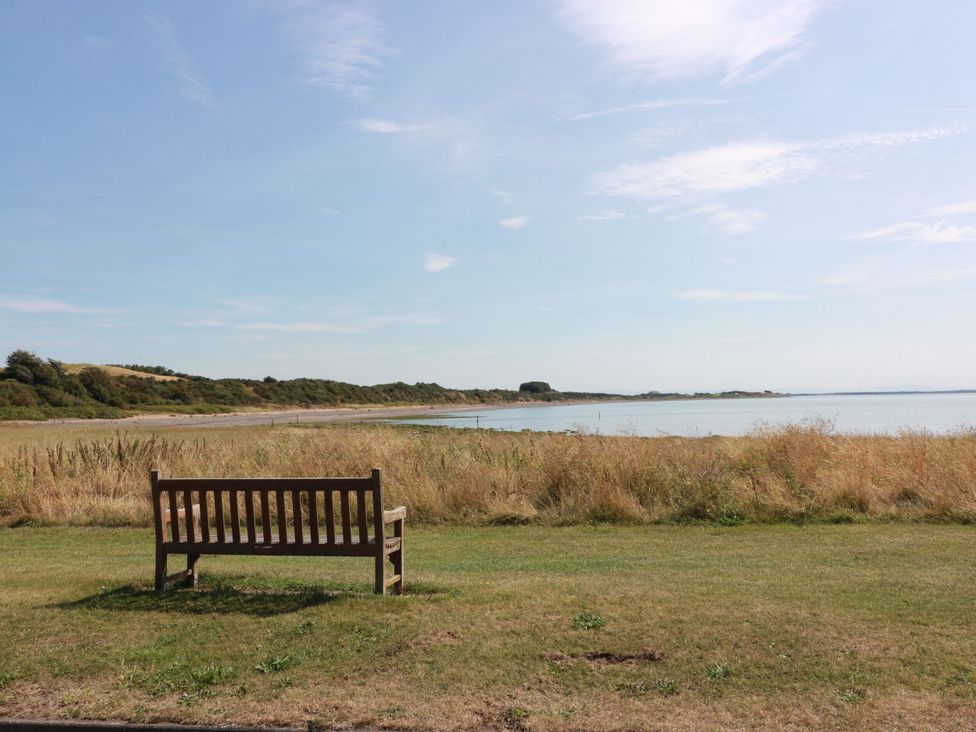 A bench overlooking a water body at Sandy Toes, Powfoot, Annan